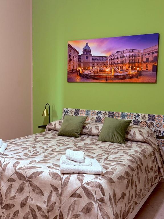 Letto matrimoniale con asciugamani e quadro decorativo